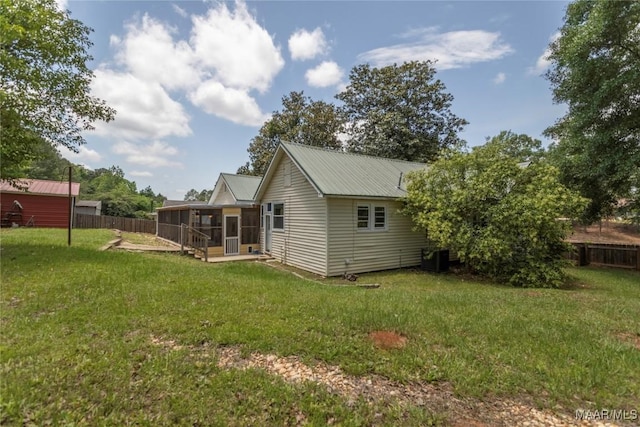 back of house with a sunroom, metal roof, and central AC