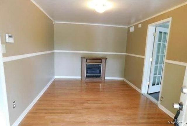 4097 Narrow Lane Rd, Montgomery, AL 36111 - unfurnished living room featuring wood finished floors, a glass covered fireplace, baseboards, and ornamental molding