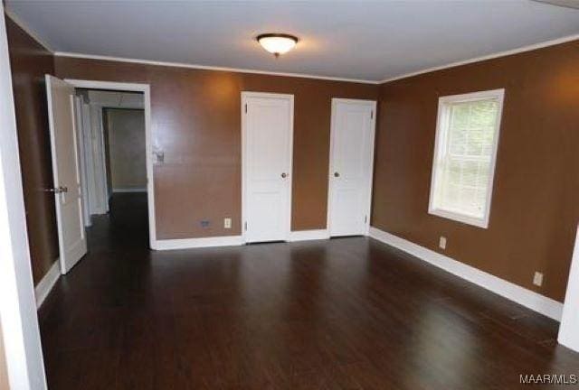 4097 Narrow Lane Rd, Montgomery, AL 36111 - unfurnished bedroom with baseboards, wood finished floors, crown molding, and two closets