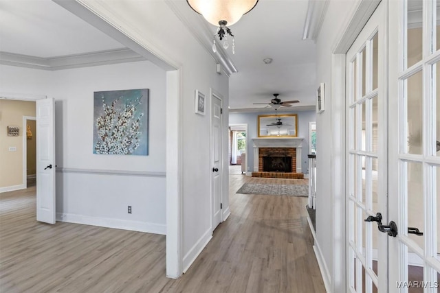 hall featuring wood finished floors, french doors, baseboards, and ornamental molding
