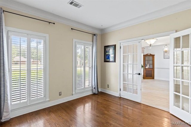spare room featuring french doors, wood finished floors, plenty of natural light, baseboards, and crown molding