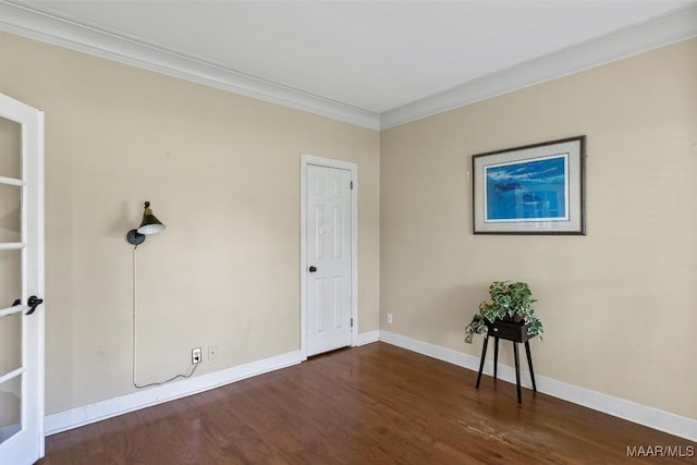 spare room featuring ornamental molding, wood finished floors, and baseboards