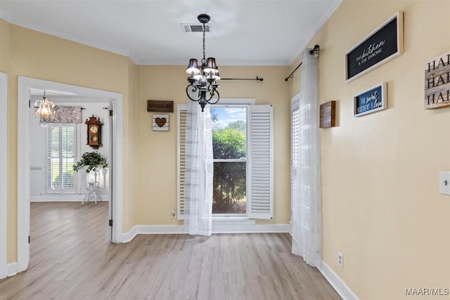 unfurnished dining area featuring a chandelier, wood finished floors, ornamental molding, and baseboards