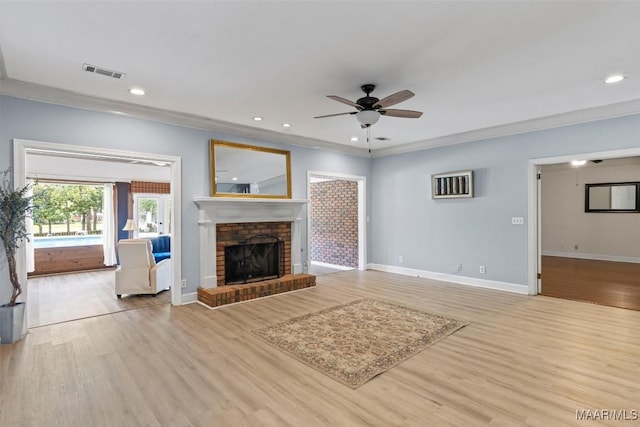 unfurnished living room featuring a ceiling fan, light wood-type flooring, baseboards, ornamental molding, and a fireplace