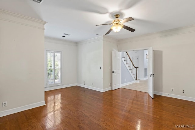 unfurnished room with ceiling fan, stairway, wood finished floors, baseboards, and crown molding