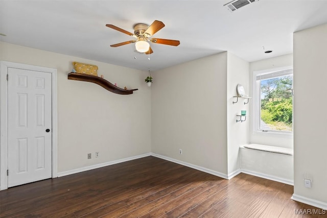 unfurnished room with wood finished floors, a ceiling fan, and baseboards