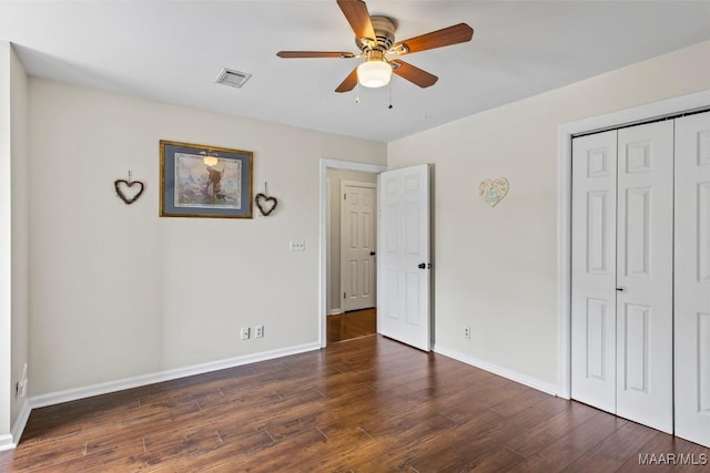 unfurnished bedroom with baseboards, wood finished floors, a closet, and ceiling fan