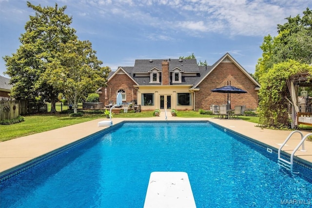 view of swimming pool with french doors, a diving board, and a patio area