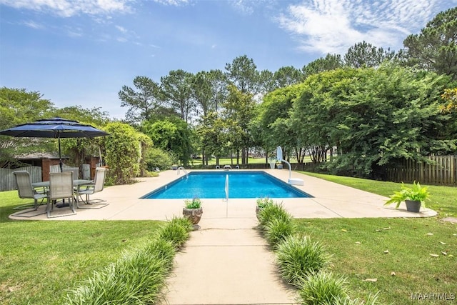 view of swimming pool featuring a patio, a water slide, and view of scattered trees