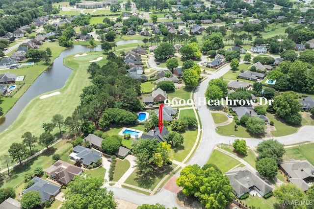 aerial view of property's location with a nearby body of water, nearby suburban area, and a golf club
