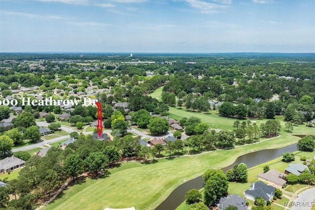 aerial perspective of suburban area with a large body of water, a golf club, and a tree filled landscape