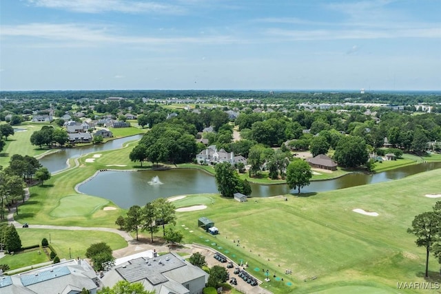 aerial view of residential area with a golf course, a nearby body of water, and a tree filled landscape