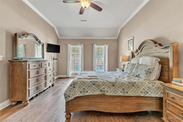 bedroom featuring ornamental molding, light wood-style floors, baseboards, lofted ceiling, and a ceiling fan