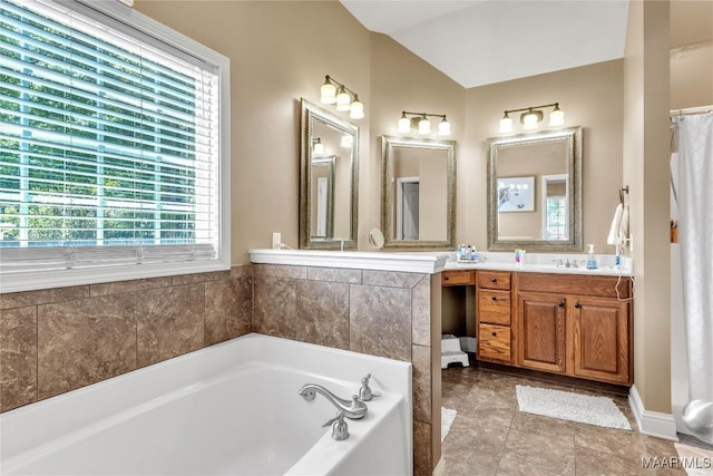 full bath featuring a bath, vanity, and lofted ceiling