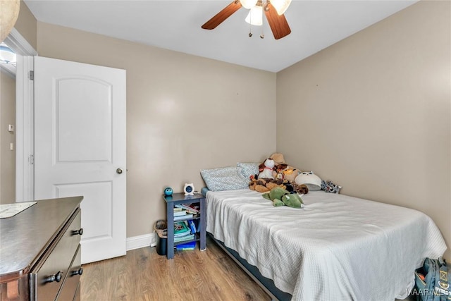 bedroom with wood finished floors, baseboards, and a ceiling fan