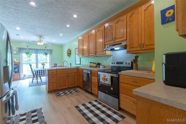 705 Yellowstone Dr, Prattville, AL 36067 - kitchen with appliances with stainless steel finishes, a peninsula, under cabinet range hood, a sink, and light wood-style floors
