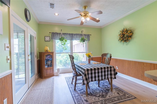 705 Yellowstone Dr, Prattville, AL 36067 - dining area featuring wainscoting, light wood-style flooring, a textured ceiling, crown molding, and a ceiling fan
