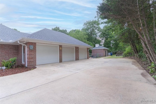 705 Yellowstone Dr, Prattville, AL 36067 - view of side of home featuring roof with shingles, brick siding, an attached garage, and driveway