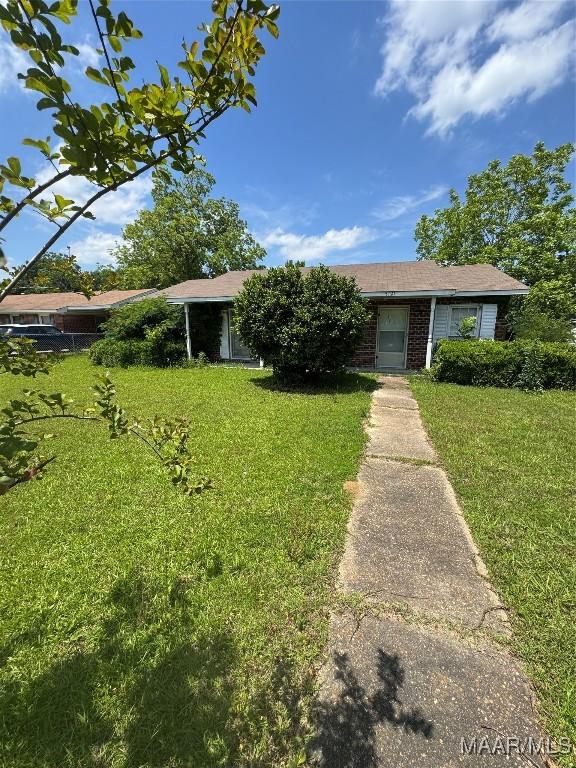 view of front of house featuring a front lawn and brick siding