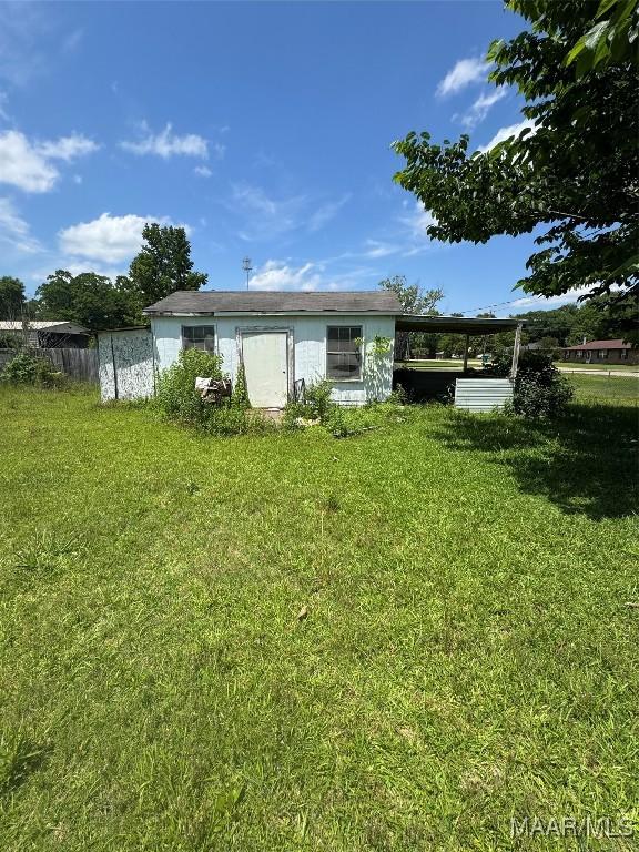 back of house featuring a yard and an attached carport