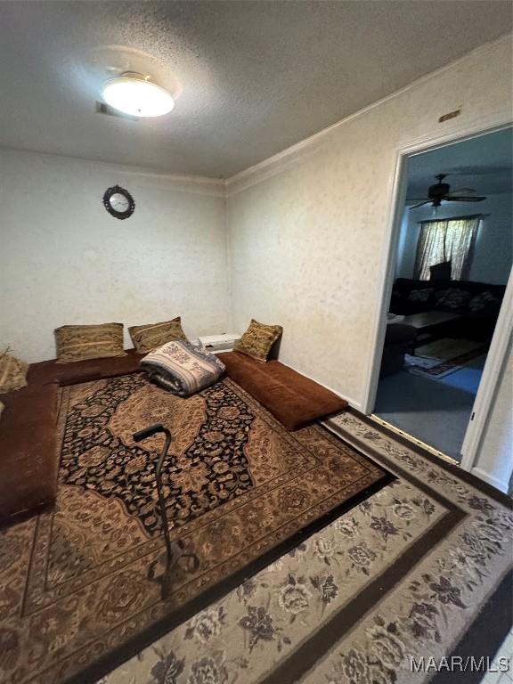 bedroom featuring a textured ceiling and crown molding