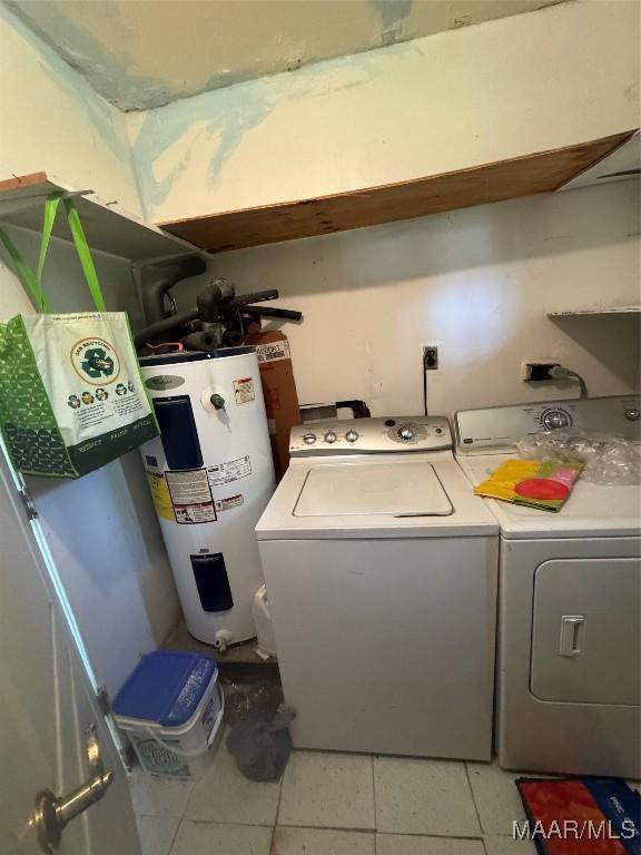 laundry area featuring electric water heater, separate washer and dryer, and light tile patterned floors