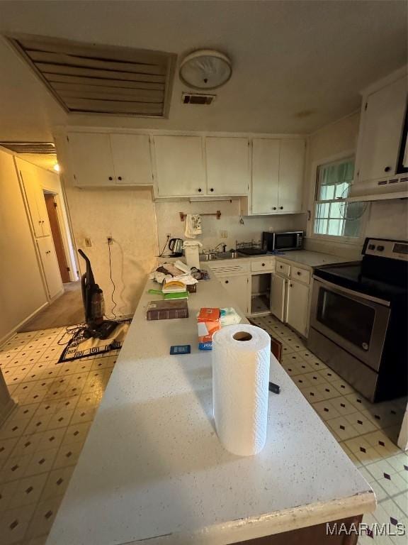 kitchen with stainless steel appliances, white cabinetry, and under cabinet range hood
