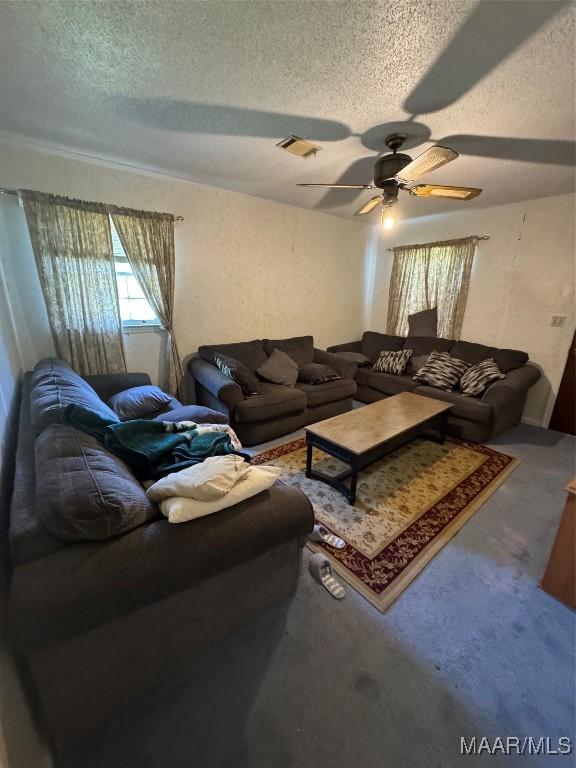 living room featuring a textured ceiling and ceiling fan