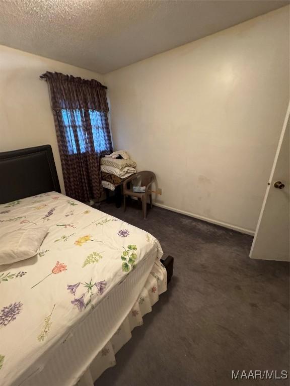 bedroom with carpet floors and a textured ceiling