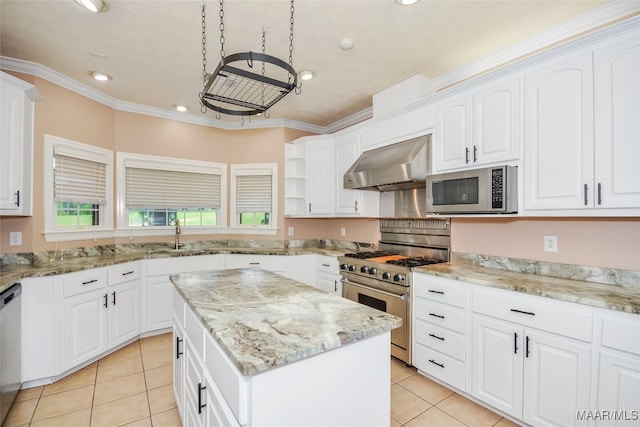 kitchen featuring wall chimney exhaust hood, stainless steel appliances, a sink, light tile patterned floors, and a kitchen island