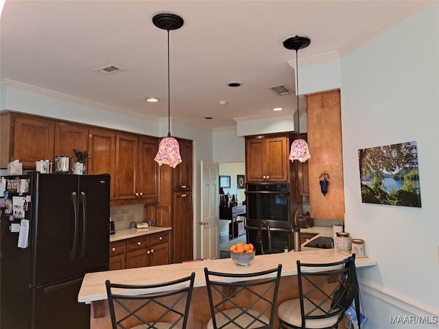 2564 Aimee Dr, Montgomery, AL 36106 - kitchen with black appliances, light countertops, a peninsula, decorative backsplash, and decorative light fixtures