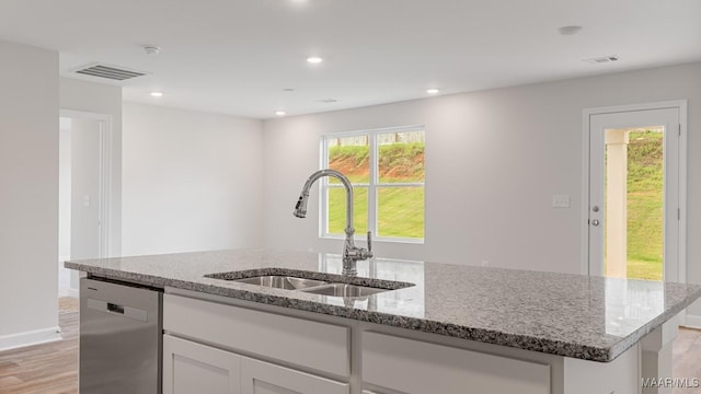 6004 Cunningham Trl, Montgomery, AL 36116 - kitchen with a sink, stainless steel dishwasher, light wood-style flooring, light stone countertops, and white cabinetry