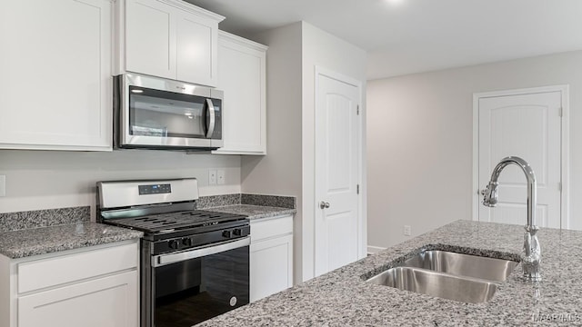 6004 Cunningham Trl, Montgomery, AL 36116 - kitchen with appliances with stainless steel finishes, a sink, light stone counters, and white cabinetry