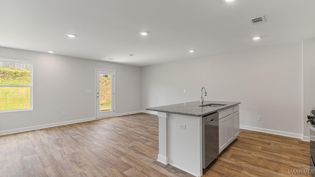 6004 Cunningham Trl, Montgomery, AL 36116 - kitchen featuring a sink, dishwasher, light wood-type flooring, dark stone counters, and baseboards