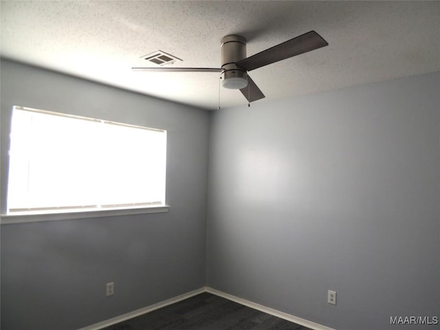 5314 Rolind Dr, Montgomery, AL 36108 - empty room with ceiling fan, dark wood-style flooring, baseboards, and a textured ceiling