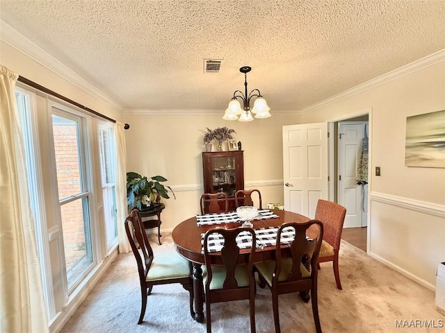36 Wilkins Rd, Selma, AL 36701 - dining area with a textured ceiling, light colored carpet, a chandelier, crown molding, and baseboards