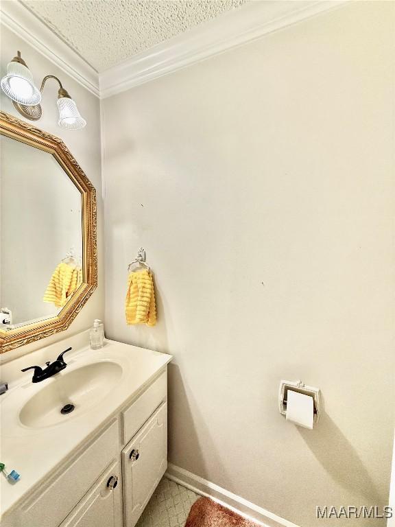 36 Wilkins Rd, Selma, AL 36701 - bathroom with crown molding, vanity, a textured ceiling, and baseboards