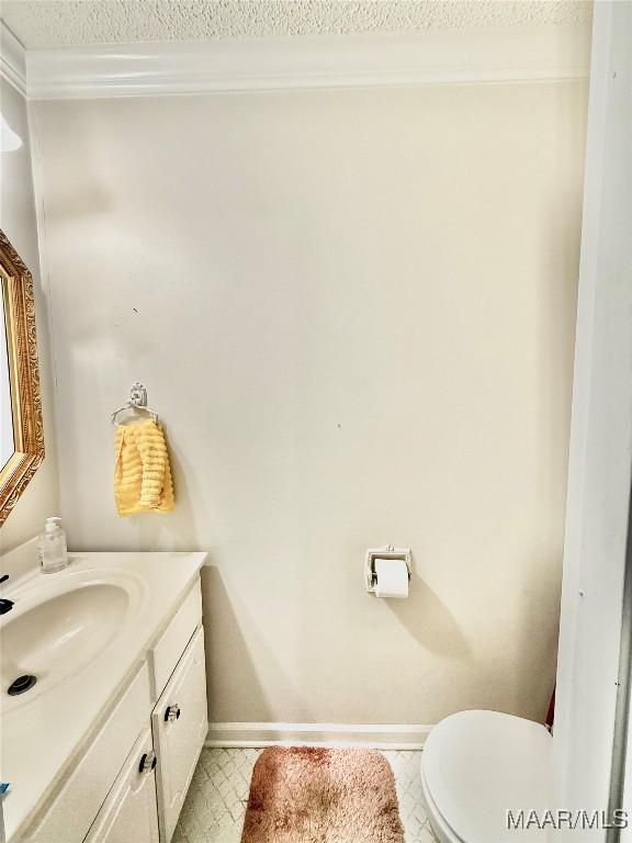 36 Wilkins Rd, Selma, AL 36701 - bathroom featuring baseboards, vanity, toilet, a textured ceiling, and ornamental molding