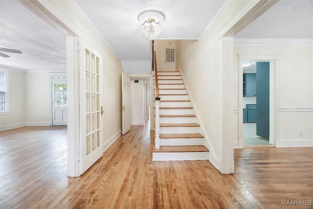 2046 Madison Ave, Montgomery, AL 36107 - staircase with wood finished floors, baseboards, a chandelier, ornamental molding, and ceiling fan