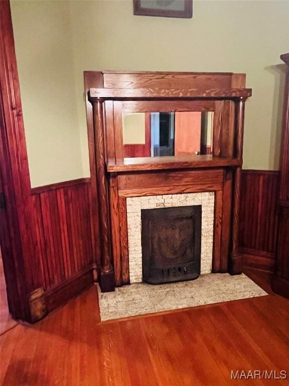 501 Tremont St, Selma, AL 36701 - detailed view of a stone fireplace, a wainscoted wall, wood finished floors, and wood walls
