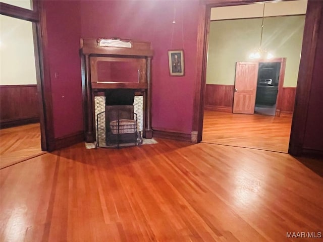 501 Tremont St, Selma, AL 36701 - unfurnished living room with wainscoting, wood finished floors, and a fireplace