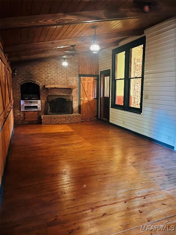 501 Tremont St, Selma, AL 36701 - unfurnished living room featuring wood ceiling with exposed beams, hardwood / wood-style floors, wood walls, and a brick fireplace