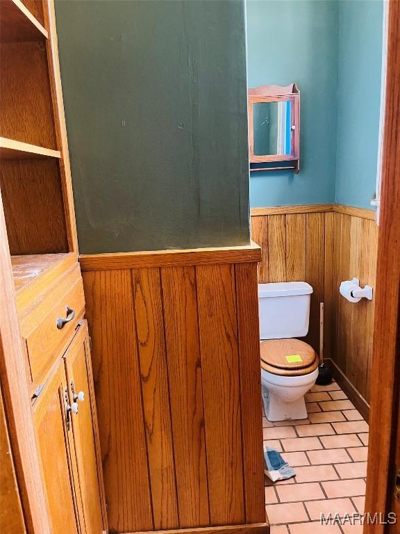 501 Tremont St, Selma, AL 36701 - bathroom featuring a wainscoted wall, toilet, wooden walls, tile patterned floors, and vanity