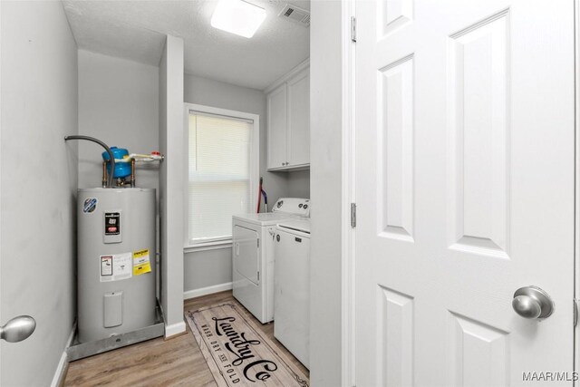 57 New Harmony Rd, Deatsville, AL 36022 - washroom featuring water heater, cabinet space, washer and dryer, light wood-style flooring, and baseboards