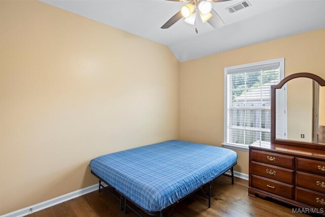 bedroom with baseboards, wood finished floors, vaulted ceiling, and ceiling fan