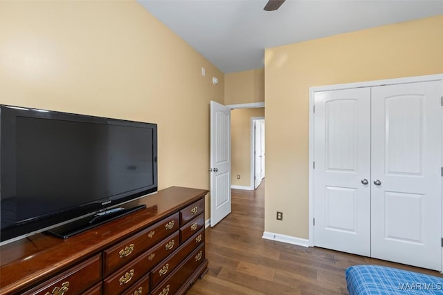 bedroom featuring dark wood finished floors, a closet, baseboards, and ceiling fan