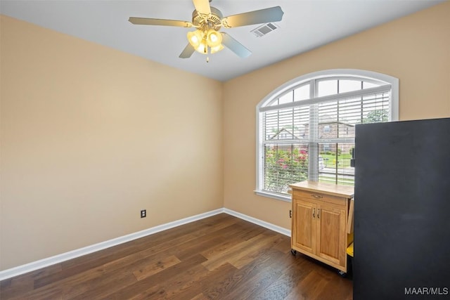 unfurnished office featuring baseboards, dark wood-style flooring, and a ceiling fan