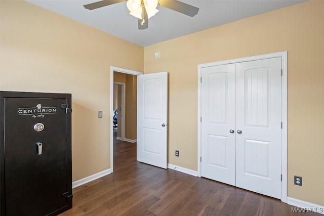 bedroom featuring dark wood-type flooring, baseboards, a closet, and ceiling fan
