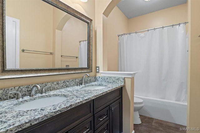 bathroom featuring double vanity, wood finished floors, shower / tub combo with curtain, and toilet