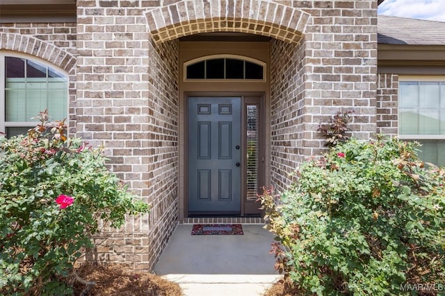 entrance to property featuring brick siding
